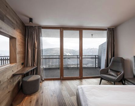Una camera d'albergo con balcone finestre in legno Topline 80
