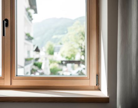 Ein Holzfenster mit Griff und Fensterbank innen