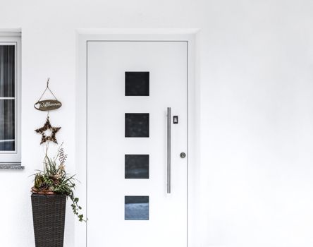Porta d'ingresso bianca in stile moderno con quattro inserti in vetro quadrati disposti verticalmente