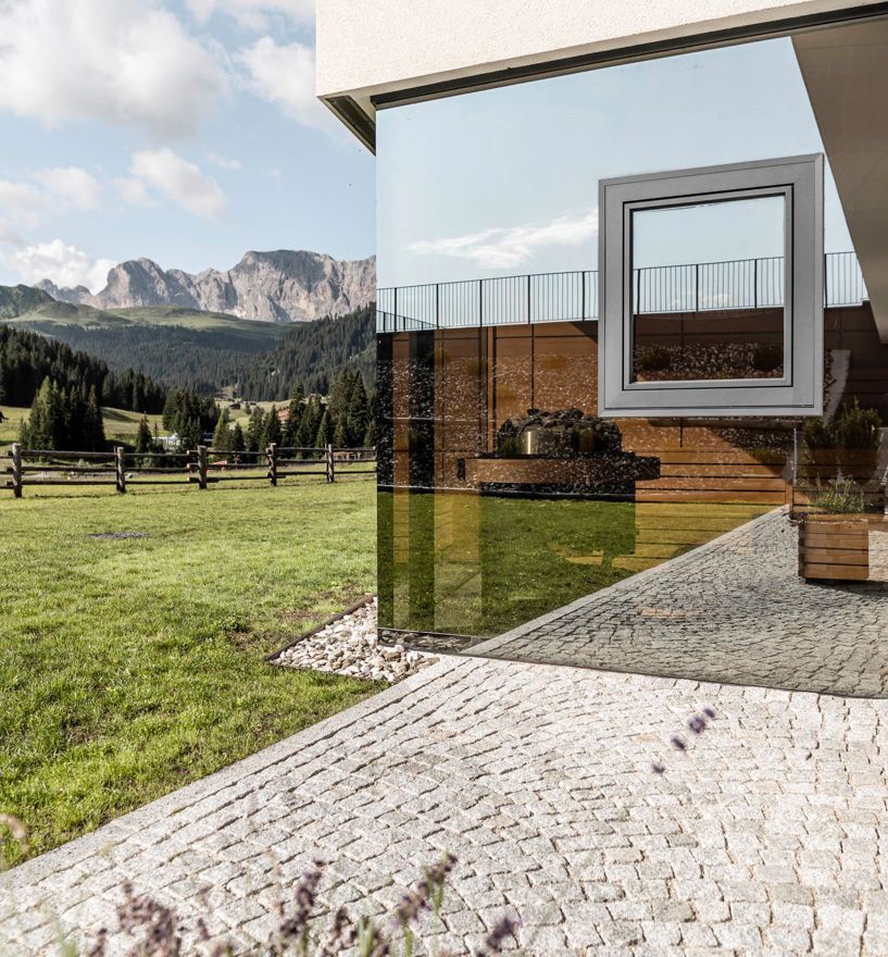 Grande vetrata frameless con giunzione ad angolo e finestra nella vetrocamera