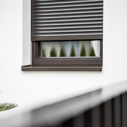 Una finestra con avvolgibili standard e davanzale esterno