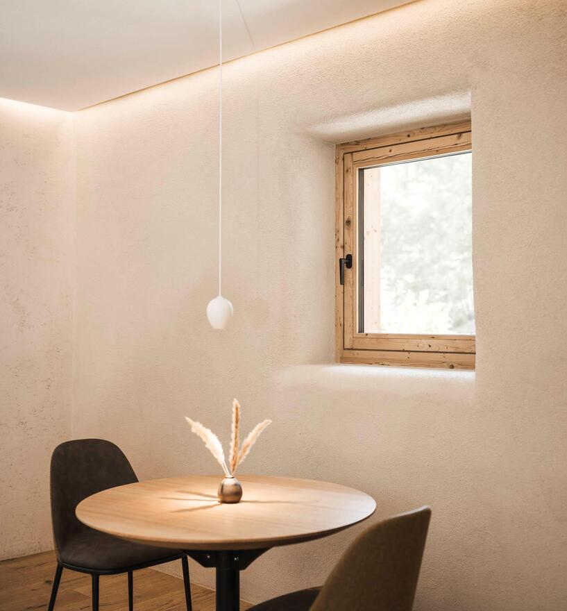 Rustikaler Gastraum mit rundem Tisch und Fensterlicht, Restaurant Drena
