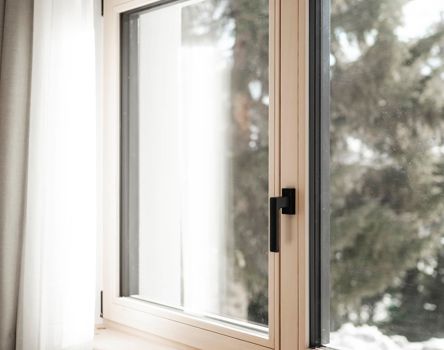 Una finestra con maniglia e davanzale interno in legno