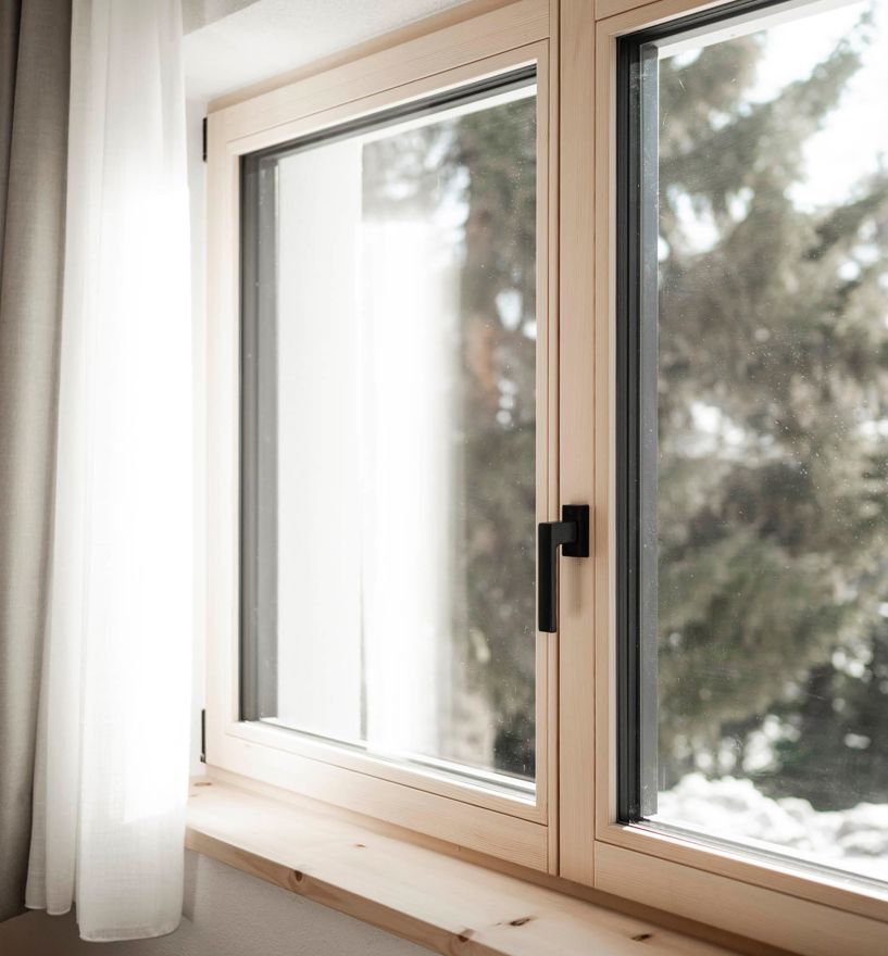 Ein Fenster mit Griff und Fensterbank aus Holz