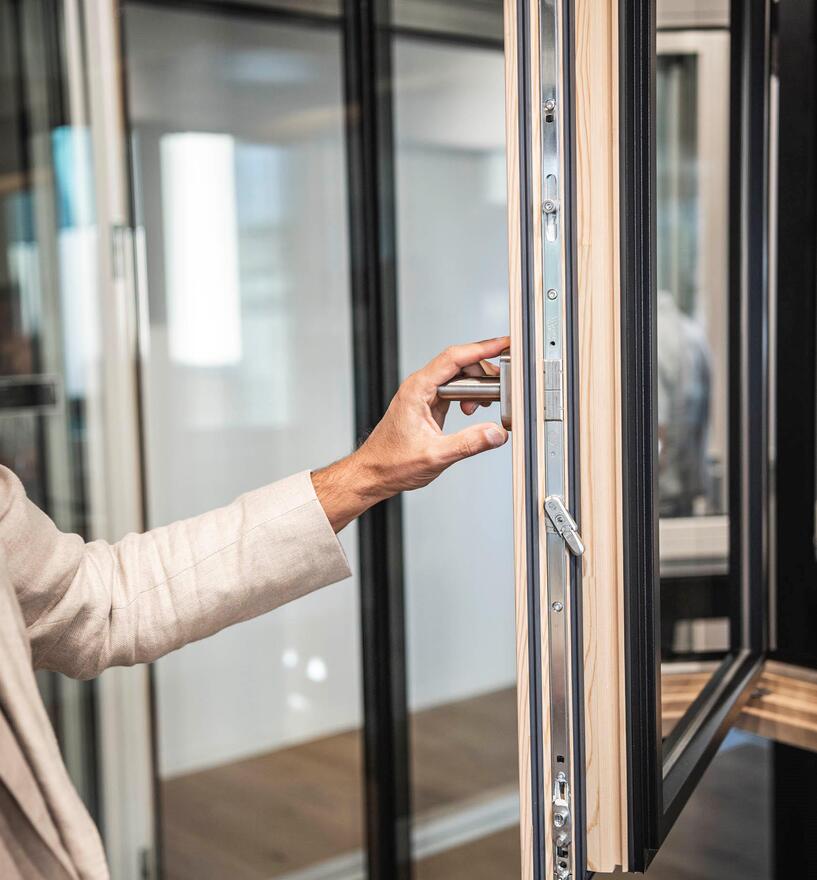 Ein Mann öffnet im Showroom ein Fenster