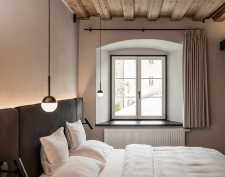 Ein Fenster mit Griff, Sprossen und Fensterbank in einem Schlafzimmer